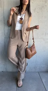 Pantalón de vestir color tostado con finas rayas verticales blancas, de corte palazzo y tiro alto.