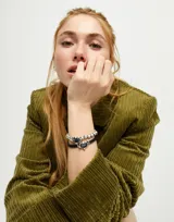 Pulsera elástica de bolas bañadas en plata con un cristal facetado grisáceo.