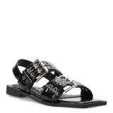 Sandalias planas Miss Carol modelo Kelmo, color negro, con tiras anchas ajustables mediante hebillas metálicas y detalle de ojales. Presentan una suela baja y punta cuadrada.