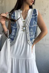 Vestido largo blanco de corte amplio con volados en el ruedo.