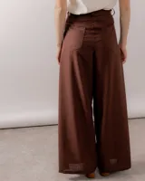 Pantalón wide leg de lino color marrón, de tiro alto con bolsillos traseros y frontales, cierre frontal con botón y bragueta.