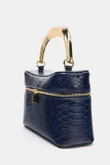 Bolso tipo vanity de color azul marino con textura de piel de serpiente en relieve. Cuenta con un asa de mano rígida metálica en tono dorado, cierre de doble cremallera y correa bandolera extraíble y ajustable.