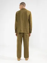 Chaqueta verde oliva de lino italiano, corte relajado, con tres bolsillos frontales y cierre con botones.