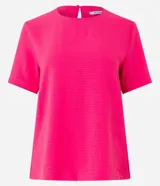 Blusa fucsia de manga corta con cuello redondo pespunteado, diseño sin estampa y efecto airflow con textura sutil. Cuenta con abertura trasera tipo gota y cierre con botón.