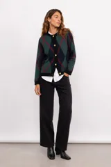 Cardigan de punto con patrón argyle en tonos bordó y rosado, con detalles en verde oscuro en cuello, puños y ruedo. Presenta cierre frontal con botones dorados.