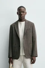 Blazer regular fit confeccionado en mezcla de lana y lino, con diseño de pata de gallo en tonos marrones y grises. Cuenta con cuello de solapas de muesca, cierre frontal de dos botones, bolsillos de plastrón en la cadera y bolsillo de vivo en el pecho.