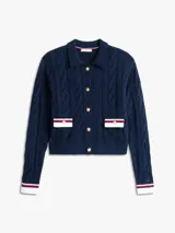 Cárdigan de punto trenzado en color azul marino, con cuello tipo polo y cierre frontal de botones dorados. Presenta dos bolsillos frontales con solapas decoradas en blanco, rojo y azul, y puños con el mismo detalle tricolor.