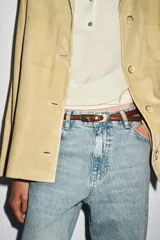 Cinturón fino de 1.5 cm de ancho, confeccionado en cuero 100%, color negro, con hebilla metálica rectangular dorada.