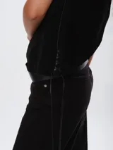 Chaleco de cuero azul marino con corte oversize, diseño sin mangas y laterales ajustables mediante cordones de cuero en tono natural.