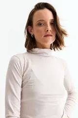 Remera básica de manga larga con cuello polera, confeccionada en tejido suave y elástico.