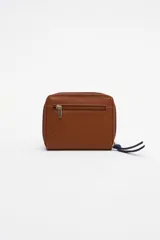 Billetera chica de cuero color rojo con cierre de cremallera y tirador celeste. Tiene bolsillo trasero y abertura al medio.