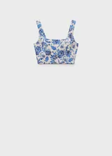 Top corto de tela color crema con estampado floral azul, de breteles anchos y escote cuadrado.