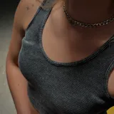 Conjunto de dos piezas compuesto por un top corto de cuello redondo y una pollera con short integrado, ambos confeccionados en algodón con efecto lavado.