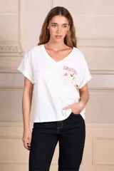 Remera blanca de algodón con escote en V y mangas cortas con dobladillo. Estampado frontal con la palabra "Martini" y un dibujo de una copa de martini.