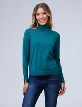 Polera de cuello alto confeccionada en hilado fino, con mangas largas y detalle de tajo en los puños.