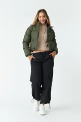 Campera corta de nylon color verde militar, con cuello alto, cierre frontal completo y bolsillos laterales.