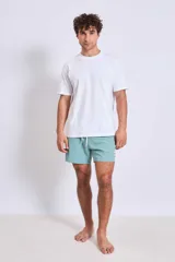 Short de baño color verde menta, con cordón ajustable en la cintura y un pequeño logo blanco en la pierna izquierda.