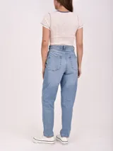 Pantalón jean de tiro alto y corte mom, color celeste, con bolsillos laterales y traseros.