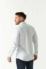 Camisa de manga larga para hombre, color azul claro con microestampado de cuadros. Presenta un corte slim y cuello abotonado.