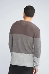 Sweater de punto con diseño color block en tonos azul marino y gris jaspeado. Presenta cuello redondo, mangas largas y un ajuste regular.