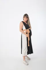 Vestido largo de corte imperio, con paneles verticales en color negro, blanco y ocre. Incluye lazo de tela ocre para ajustar debajo del busto.