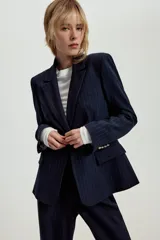 Blazer entallado de color azul marino con estampado de rayas diplomáticas, cuello con solapa, hombreras, manga larga y cierre frontal con un botón. Cuenta con bolsillos delanteros con solapa.