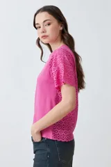 Remera fucsia de manga corta con detalle de broderie en las mangas.