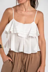 Top de algodón color blanco, con tirantes finos, escote recto y detalle de volados amplios en el pecho con apliques de encaje.