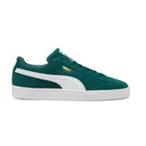 Championes Puma modelo Suede Classic confeccionados en gamuza de color verde oscuro, con la franja icónica de la marca en los laterales de color blanco, suela de goma blanca y el logotipo dorado en el lateral.