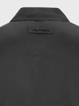 Campera negra con cuello camisero, cierre frontal con cremallera, dos bolsillos laterales y logo de Tommy Hilfiger bordado en el pecho.