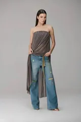 Pantalón de jean azul con corte recto y estilo destroyed, con roturas en las rodillas y desgaste localizado.