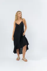 Vestido negro midi con tirantes finos y escote en V. Diseño fluido con bajo asimétrico.