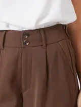 Pantalón palazzo de tiro alto en color verde militar, con diseño de doble abotonadura frontal, pinzas en la cintura y pierna ancha. Cuenta con cintura elástica en la parte posterior para mayor ajuste y bolsillos laterales funcionales.