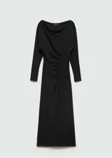 Vestido largo negro de diseño entallado, con escote asimétrico tipo off-shoulder y manga larga. Presenta detalles fruncidos laterales que realzan la silueta.
