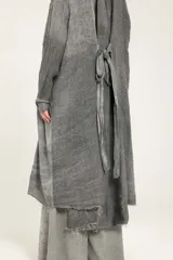 Blazer largo tipo guardapolvo de lino puro color gris con mangas caídas, solapas, cierre de un botón y bordes deshilachados.