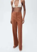 Pantalón de vestir color ladrillo, de tiro alto, corte recto y largo. Confeccionado en tejido mezcla de algodón y lino, con cierre delantero de cremallera, doble gancho y botón interior.