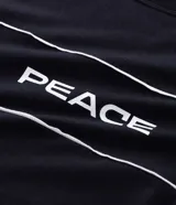 Remera oversized negra de algodón con cuello redondo, mangas cortas amplias y estampado frontal con la palabra "PEACE" en blanco, acompañada de dos líneas horizontales blancas.