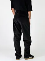 Pantalon de pana color marron oscuro, de corte recto y tiro medio, con costuras reforzadas en las rodillas y cierre frontal con boton.