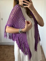 Chal tejido en crochet color violeta, con diseño de red y terminaciones de flecos en los bordes.