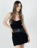Vestido corto negro con breteles finos, corte entallado y falda suelta.
