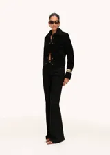 Chaqueta corta de piel bovina serraje color negro, con cuello camisero, bolsillos de parche con solapa en el frente, manga larga y cierre frontal de botones.