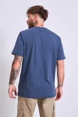 Remera azul marino de algodón con cuello redondo y manga corta. Presenta un pequeño bordado de un pájaro en el área del pecho.