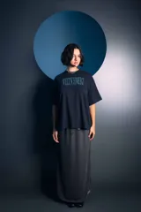Falda midi de color gris, con diseño de frunces laterales que crean un efecto drapeado y una abertura lateral. Confeccionada en tejido de punto con textura.