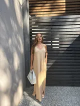 Vestido largo color beige, de viscosa, con tirantes finos, escote en V y aberturas laterales en la falda.