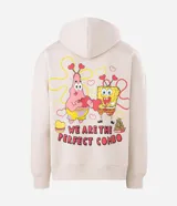 Buzo con capucha de corte boxy, color beige, con bolsillo canguro frontal y estampa bordada de Bob Esponja y Patricio en el pecho. Presenta puños y cintura acanalados, y cordones ajustables en la capucha.