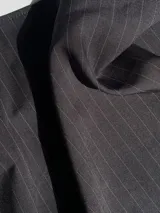 Pantalón sastrero gris a rayas verticales, de tiro alto con bolsillos y pretina trasera elastizada.