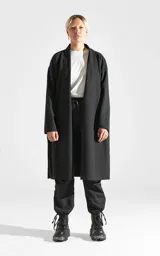 Sacón largo de corte regular, confeccionado en tela simil paño color gris oscuro. Presenta diseño abierto, mangas largas con terminaciones al corte y bolsillos laterales ocultos.