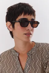 Lentes de sol con marco negro y patillas color carey.