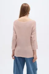 Sweater de tejido acrílico de corte holgado, color rosado, con cuello redondo y mangas 3/4.