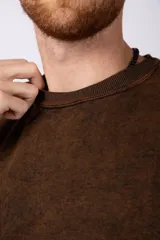 Remeron de algodón rústico con efecto de lavado gastado, corte oversize, cuello redondo y mangas cortas con terminaciones al corte.